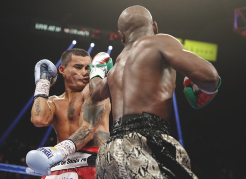 Floyd Mayweather punches Marcos Maidana, left, during their title boxing bout in Las Vegas