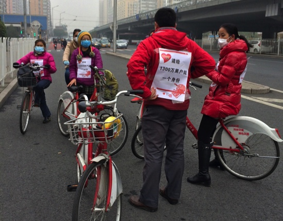 In this Saturday, Nov. 14 photo provided by a demonstrator who wished to remain anonymous, demonstrators urging the Chinese government to recognize unregistered children gather along the side of a road before bicycling to Tiananmen Square in Beijing