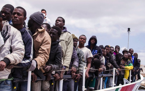 Migrants wait to disembark from the Italian Coast Guard ship Peluso, onto the tiny Italian island of Lampedusa