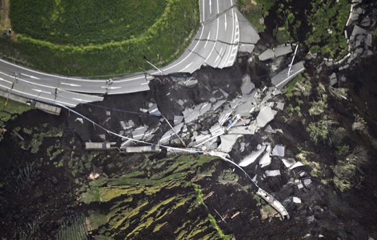 In this aerial photo, the landslide caused by the earthquake disrupts the road in Minamiaso town